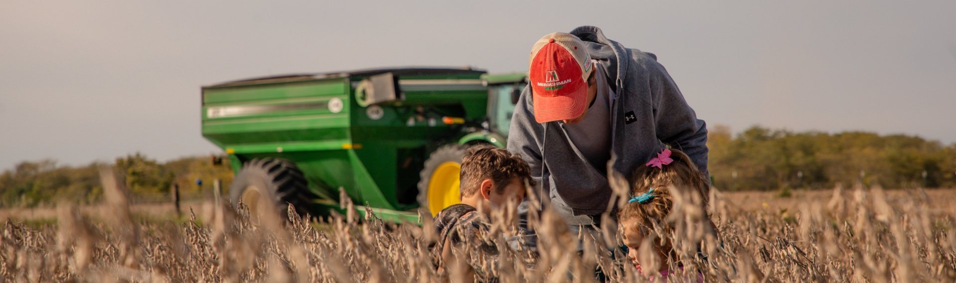 Photo of a farming family looking at soybeans.